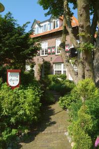 une maison avec un panneau devant elle dans l'établissement Villa Hoog Duin, à Domburg