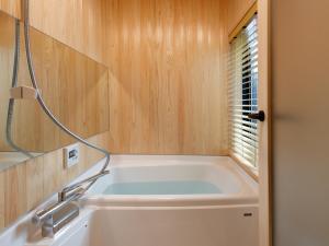 a bath tub in a bathroom with a window at Kanade Fushimiinari-Taishame in Kyoto +10 photos