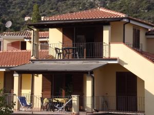 ein Haus mit einem Balkon mit einem Tisch und einem Stuhl in der Unterkunft Yellon House in Santa Maria Navarrese