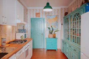 a kitchen with blue cabinets and a blue door at Habari We Dorm in Bari