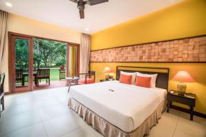 a bedroom with a large bed and a patio at Pandanus Resort in Mui Ne