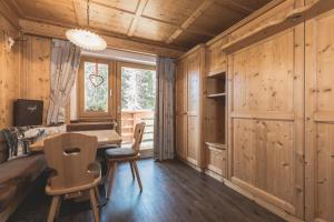 ein Raum mit Holzwänden, einem Schreibtisch und einem Fenster in der Unterkunft Residence Ciasa Vedla in Abtei