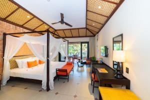 a bedroom with a bed and a desk in a room at Pandanus Resort in Mui Ne