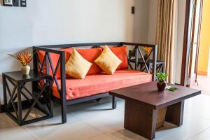 a couch with orange pillows in a living room at Pandanus Resort in Mui Ne