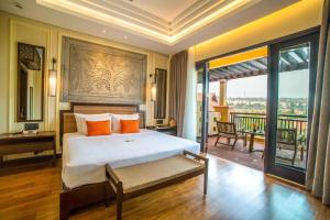 a bedroom with a large bed and a balcony at Pandanus Resort in Mui Ne