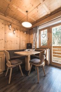 ein Holzzimmer mit einem Tisch und zwei Stühlen in der Unterkunft Residence Ciasa Vedla in Abtei