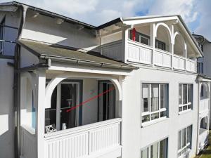 een wit huis met een raam met een rode pijl bij Haus Holstein Whg 07 mit Balkon in Ostseebad Sellin