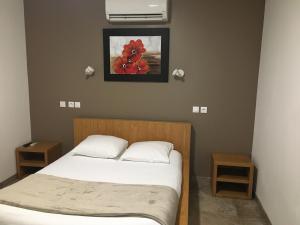 Un dormitorio con una cama y un cuadro en la pared. en Hotel de la Gare, en Mont-de-Marsan