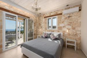 a bedroom with a bed and a large window at Grapevine Cottage in Argostoli