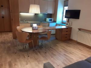 a kitchen with a table and chairs in a room at Apartaments Vall de Núria in Queralbs