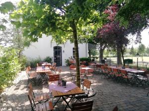 patio ze stołami i krzesłami pod drzewami w obiekcie Hotel Xtra Gleis w mieście Hörstel