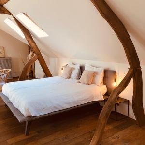 ein Schlafzimmer mit einem großen weißen Bett im Dachgeschoss in der Unterkunft B&B Slapen bij St Pieter in Lanaken