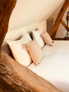 a bed with four pillows on top of it at B&B Slapen bij St Pieter in Lanaken