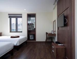 1 dormitorio con 1 cama y TV de pantalla plana en Boston Halong Hotel, en Ha Long