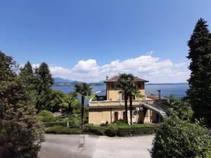 a house on a hill with a view of the water at BMP APARTMENT GIOIOSA 2 giardino vista Lago Maggiore in Belgirate