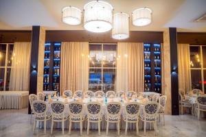 a table and chairs in a room with wine bottles at Manhattan Hotel & Restaurant in Chişinău