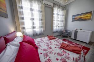 a bedroom with a bed with a red and white blanket at Liberty House (by Vacation Service) in Cefalù
