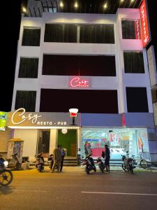 un groupe de personnes debout devant un bâtiment dans l'établissement COSY CHAMBRE, à Pondichéry