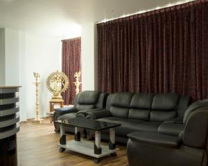 COSY CHAMBRE في بونديتْشيري: غرفة معيشة مع أريكة وطاولة
