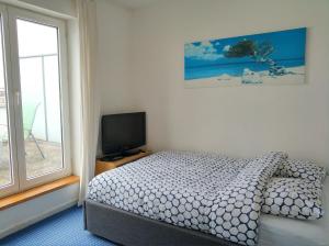 a bedroom with a bed and a flat screen tv at StudioLille - Gambetta in Lille