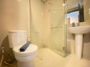 a bathroom with a toilet and a sink and a shower at Deluxe & Well Appointed 2BR at El Royale Apartment By Travelio in Bandung +17 photos