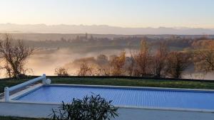 a swimming pool on top of a house with a view of a river at Magnolia résidence Domaine Cap de Coste in Saint-Frajou