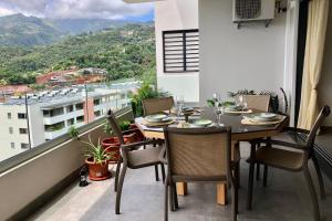 a dining room with a table and chairs on a balcony at Alicia's Sky flat on the heights with nice view on the sea and Papeete in Papeete