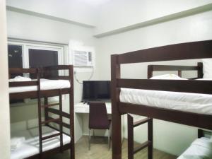 Pokój z 2 łóżkami piętrowymi i biurkiem z komputerem w obiekcie White Knight Hotel Saint Anne w mieście Manila