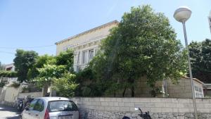 um carro estacionado em frente a um edifício com uma árvore em Apartment Wild Orange em Dubrovnik