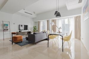 a living room with a couch and a table and chairs at Blue Arch - Luxury Serviced Apartment in Central Saigon in Ho Chi Minh City