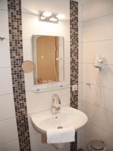 a bathroom with a sink and a mirror at Bettmann regional Einkaufen & Bauernhofurlaub in Ennigerloh
