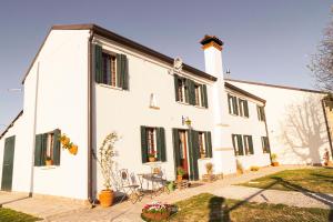 a white house with black windows and a patio at Bed & Breakfast Corte Zen in Adria