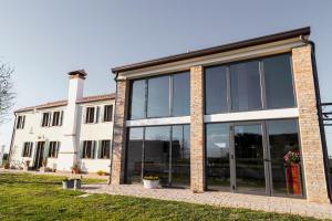 una casa con grandes puertas de cristal delante de ella en Bed & Breakfast Corte Zen en Adria