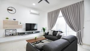 a living room with a couch and a tv at Desaru Home Feel Theme by Joyfully 13M1 in Desaru