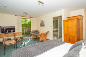a bedroom with a bed and a desk and a table at Arrowtown House Boutique Hotel in Arrowtown +55 photos