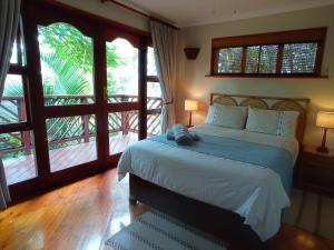 a bedroom with a bed in a room with windows at Villa Spa Holiday Resort in Illovo +62 photos