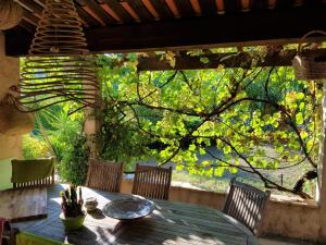 una mesa y sillas en un patio con un árbol en Villa Eglantine, en Peymeinade