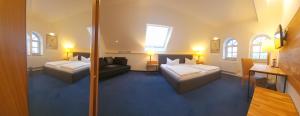 ein Hotelzimmer mit 2 Betten und einem Sofa in der Unterkunft Pension Marlis in Reichenberg