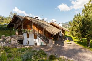 a wooden house with a balcony in a field at Chalet La Stua in Cavalese