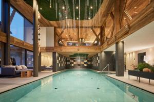 a swimming pool in a house with wooden ceilings at Hotel Marmolada in Corvara in Badia