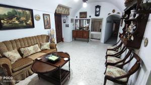- un salon avec un canapé, une table et des chaises dans l'établissement Cueva de la abuela, à Los Carriones