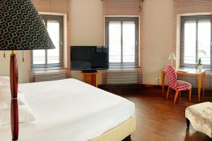 1 dormitorio con 1 cama, TV y silla en Yours Truly, en Múnich