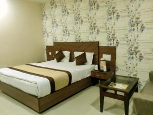 格德拉Hotel The Vaishno Devi Hills的一间卧室配有一张大床和一张桌子,床上铺有羊绒
