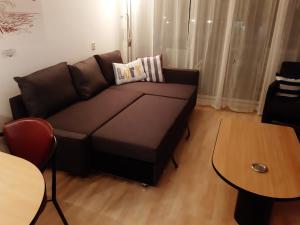 ein Wohnzimmer mit einem braunen Sofa und einem Tisch in der Unterkunft Appartement 19 Callantsoog in Callantsoog