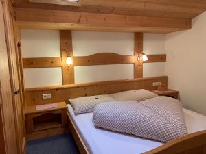 Schlafzimmer mit einem Bett mit einem Kopfteil aus Holz in der Unterkunft Haus Witting in Leutasch