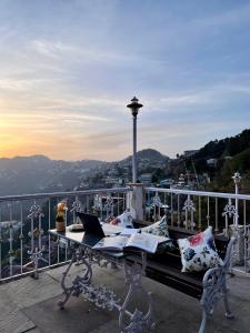 a table with a laptop on top of a balcony at Tree of Life Highlands Mussoorie in Mussoorie