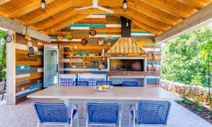 una cocina al aire libre con mesa y sillas en un patio en Villa Majkovica, en Orasac