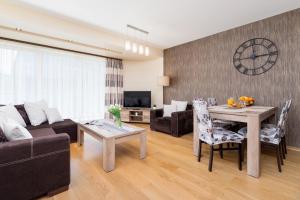 a living room with a couch and a table at Stara Polana Apartamenty & Spa Zakopane by Noclegi Renters in Zakopane