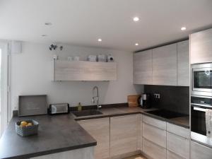 a kitchen with wooden cabinets and a sink at REF 123 Maison T5 pour huit personnes proche plage à Arzon in Arzon +21 photos