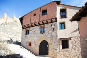 an old stone building with a door and stairs at Apartamento Subida Las Torres in Albarracín